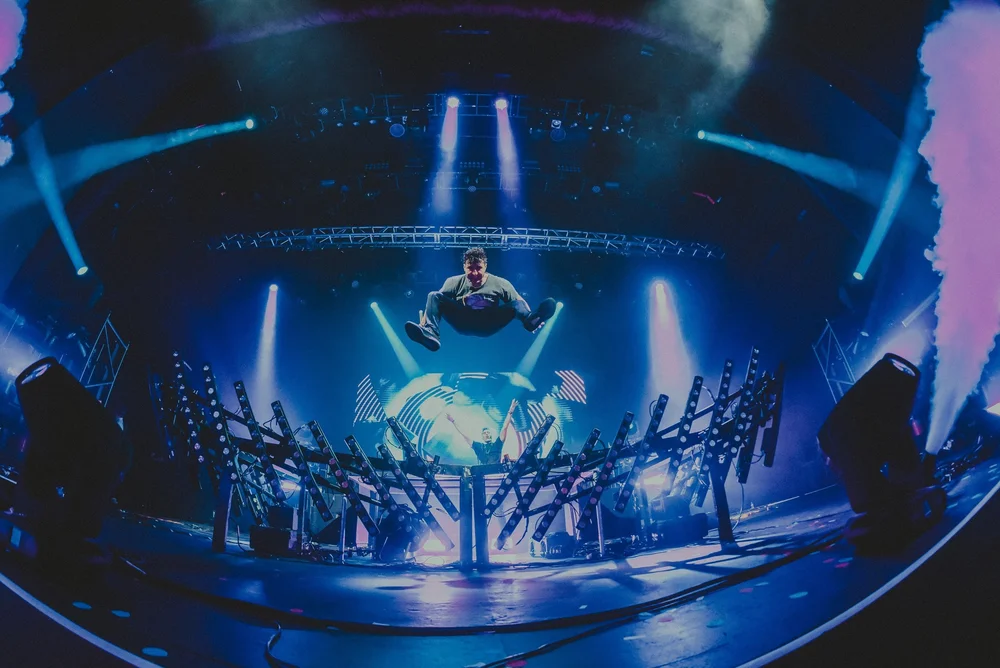A concert stage framed by blue beams of light